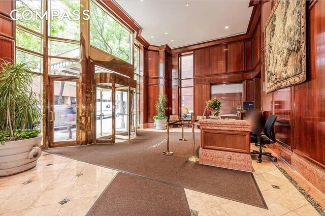 office area featuring wooden walls, inlaid floor details, a high ceiling, and recessed lighting