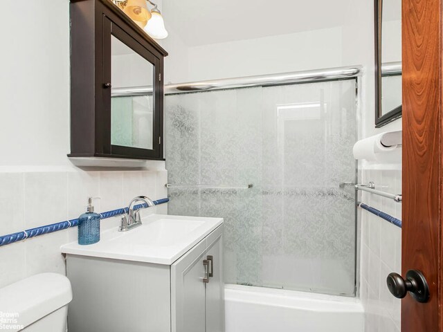 5800 Arlington Ave Unit 7L, New York City, NY 10471 - full bathroom with tile walls, toilet, vanity, and combined bath / shower with glass door