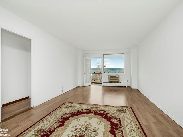 5800 Arlington Ave Unit 7L, New York City, NY 10471 - unfurnished room with wood finished floors, baseboards, and an AC wall unit