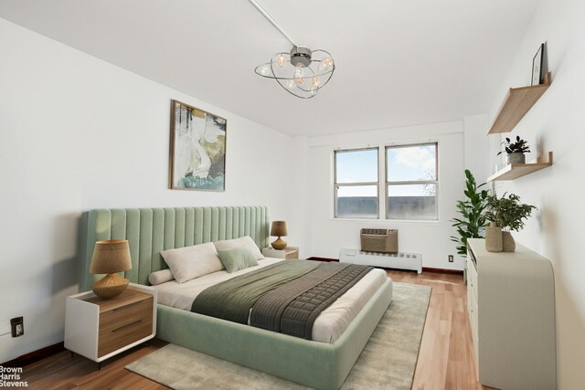 5800 Arlington Ave Unit 7L, New York City, NY 10471 - bedroom with a chandelier, wood finished floors, a baseboard heating unit, and baseboards