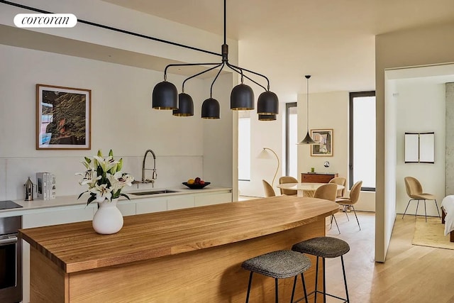 9 Chapel St Unit 5C, New York City, NY 11201 - kitchen with a sink, oven, light wood-type flooring, butcher block counters, and a kitchen breakfast bar