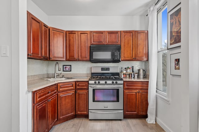206A 29th St, New York City, NY 11232 - kitchen featuring light wood finished floors, a sink, stainless steel range with gas cooktop, black microwave, and tasteful backsplash