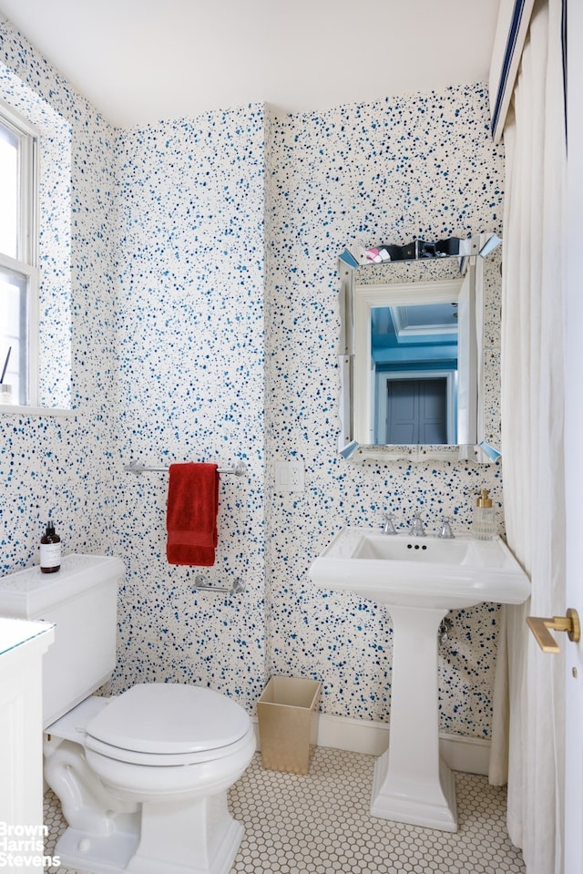 bathroom featuring tile patterned flooring, tile walls, toilet, and decorative backsplash