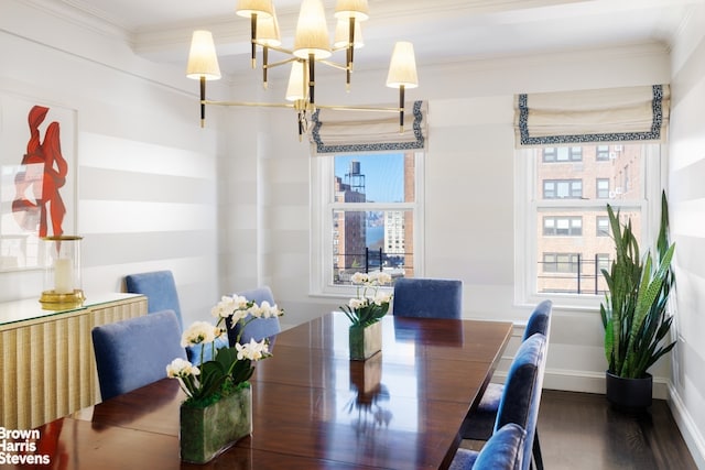 dining room with a chandelier, crown molding, and wood finished floors