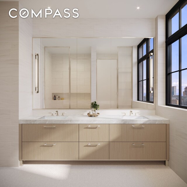 bathroom featuring double vanity and tile walls