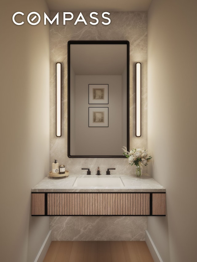 bathroom featuring a sink, wood finished floors, and baseboards