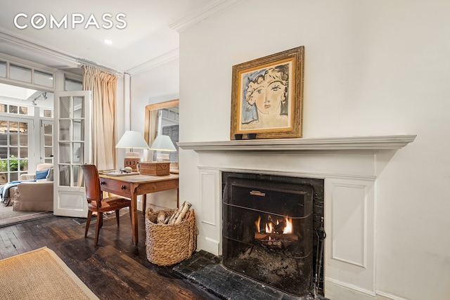 living area with french doors, dark wood-style floors, a warm lit fireplace, and crown molding
