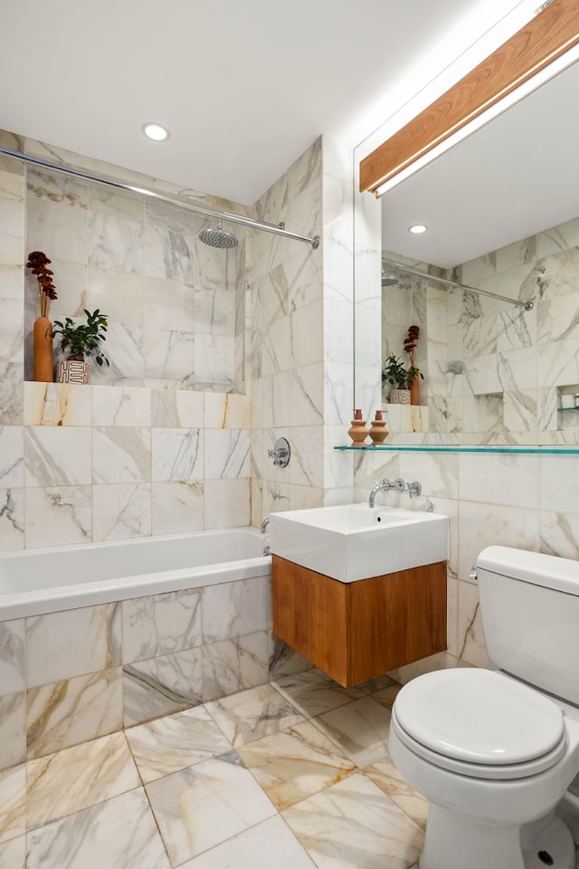 full bathroom with vanity, marble finish floor, toilet, tile walls, and tiled shower / bath