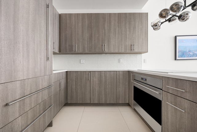 111 Fulton St Unit 318, New York City, NY 10038 - kitchen featuring oven, light countertops, light tile patterned flooring, modern cabinets, and tasteful backsplash