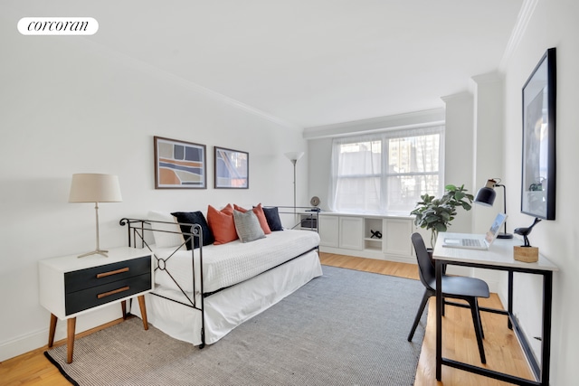 bedroom with light wood finished floors, ornamental molding, and visible vents