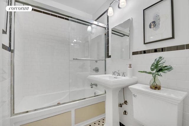 full bath with toilet and bath / shower combo with glass door