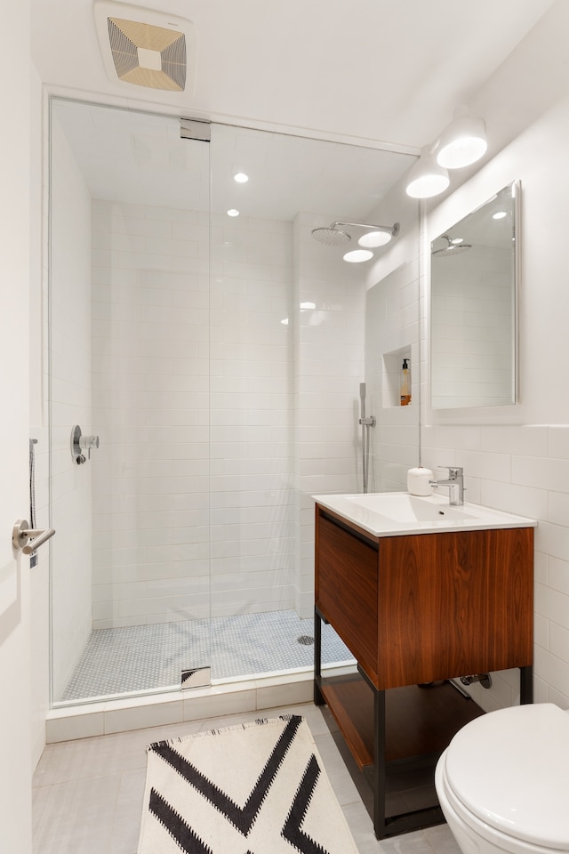 121 Mercer St Unit 4-Flr, New York City, NY 10012 - bathroom featuring a shower stall, vanity, toilet, tile walls, and tile patterned flooring