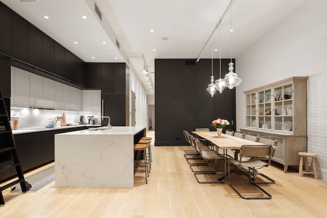 121 Mercer St Unit 4-Flr, New York City, NY 10012 - dining space with light wood-type flooring, a high ceiling, and a chandelier
