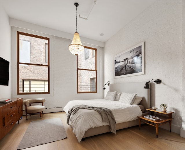 121 Mercer St Unit 4-Flr, New York City, NY 10012 - bedroom with light wood finished floors, baseboard heating, and a chandelier
