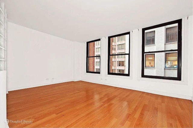 unfurnished room featuring wood finished floors and a healthy amount of sunlight