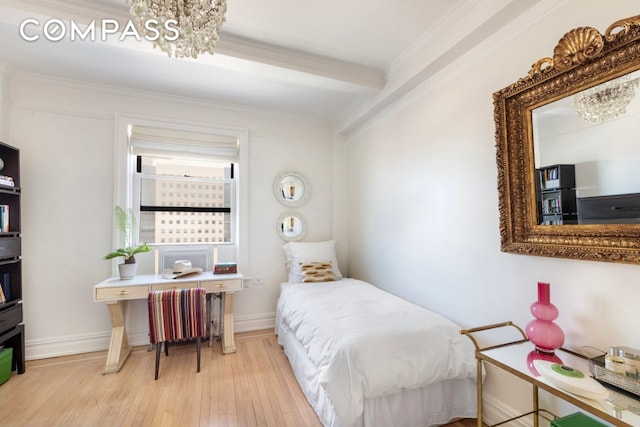 65 E 96th St Unit 15D, New York City, NY 10128 - bedroom with a chandelier, radiator heating unit, hardwood / wood-style flooring, baseboards, and ornamental molding