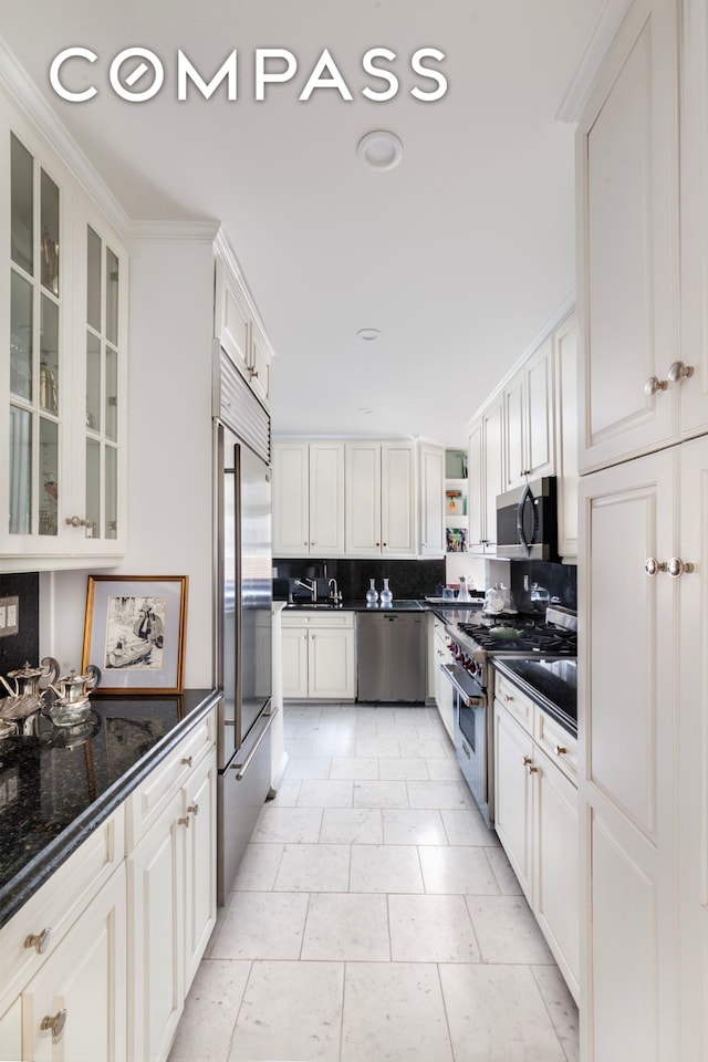 65 E 96th St Unit 15D, New York City, NY 10128 - kitchen featuring high end appliances, white cabinetry, glass insert cabinets, backsplash, and recessed lighting