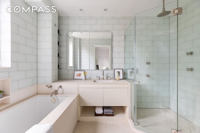 180 E 79th St Unit 14G, New York City, NY 10075 - bathroom with a stall shower, a garden tub, tile patterned floors, tile walls, and vanity