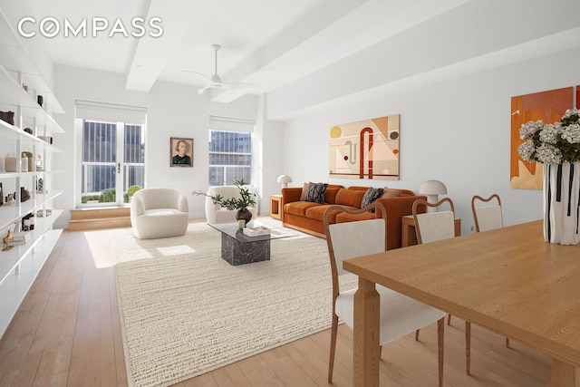 living area featuring hardwood / wood-style flooring, ceiling fan, and beamed ceiling