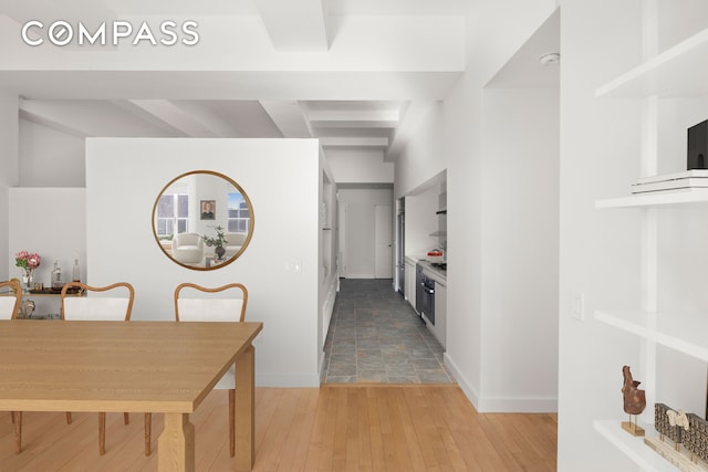 hallway featuring light wood-style flooring and baseboards