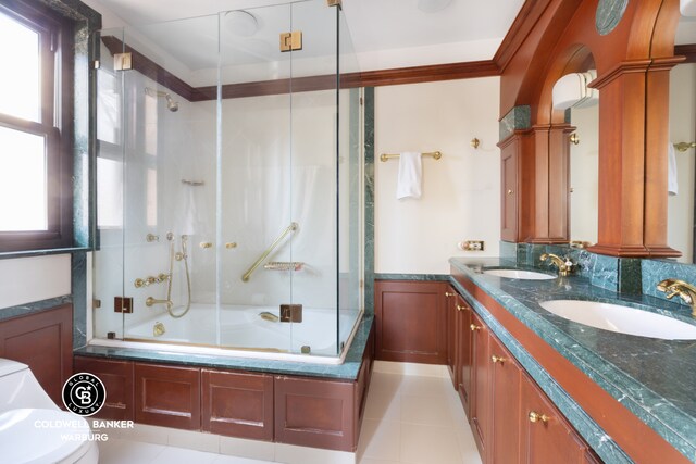 170 E 79th St Unit 9/10B, New York City, NY 10075 - full bath featuring healthy amount of natural light, bath / shower combo with glass door, double vanity, tile patterned flooring, and ornamental molding