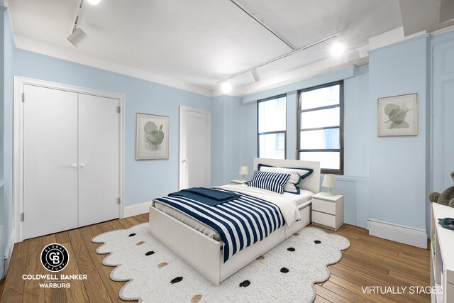 170 E 79th St Unit 9/10B, New York City, NY 10075 - bedroom with rail lighting, wood finished floors, and baseboards