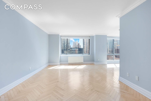 spare room featuring baseboards, ornamental molding, and a healthy amount of sunlight