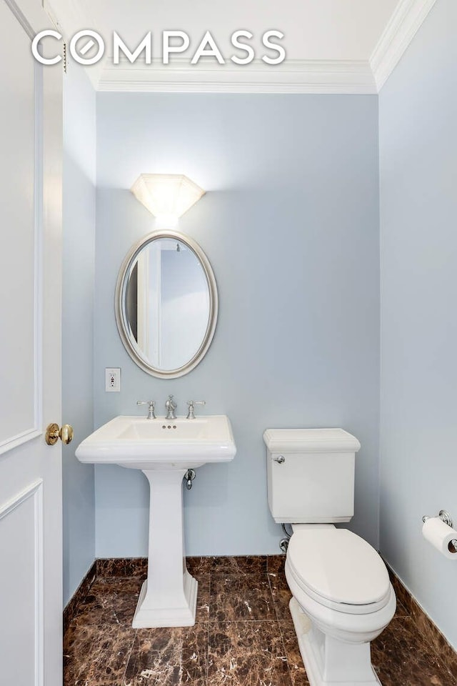 half bath with baseboards, ornamental molding, marble finish floor, and toilet