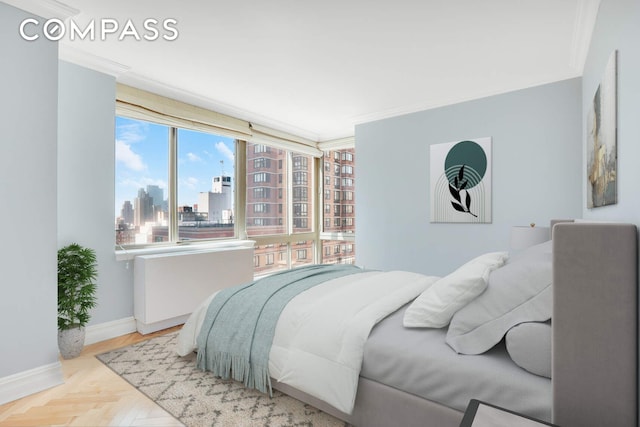 bedroom featuring crown molding, baseboards, and a city view