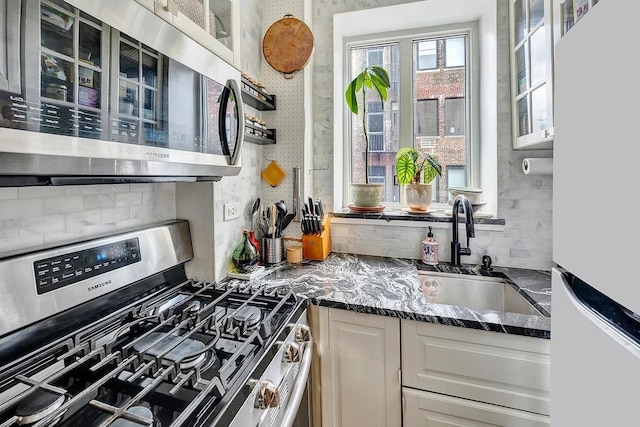 200 W 20th St Unit 1213, New York City, NY 10011 - kitchen with stainless steel appliances, a sink, tasteful backsplash, and glass insert cabinets