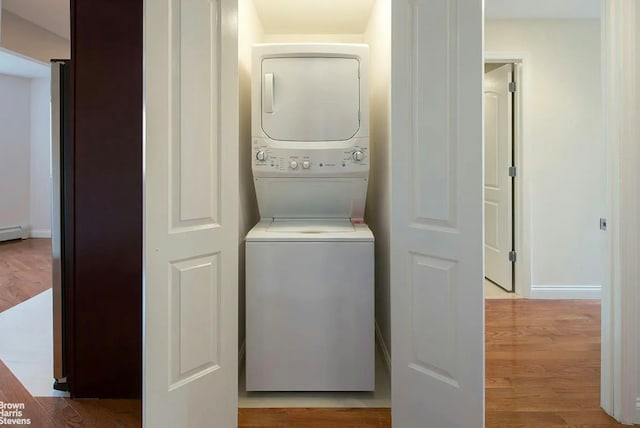 456 W 167th St Unit 7B, New York City, NY 10032 - laundry area with stacked washer / drying machine, wood finished floors, and baseboards