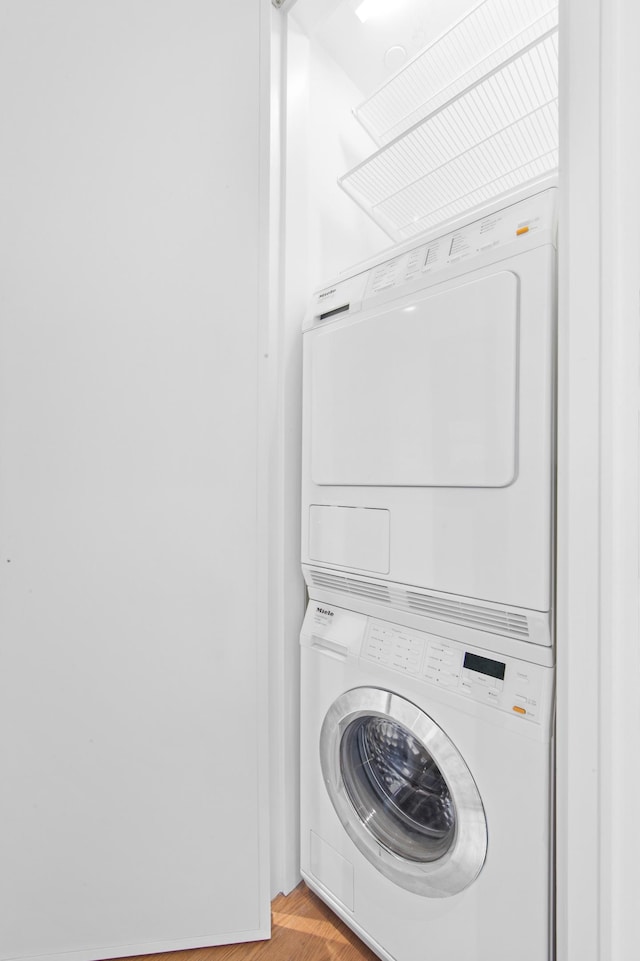 5 Beekman St Unit 22C, New York City, NY 10038 - laundry room featuring stacked washer / drying machine, light wood-style flooring, and laundry area