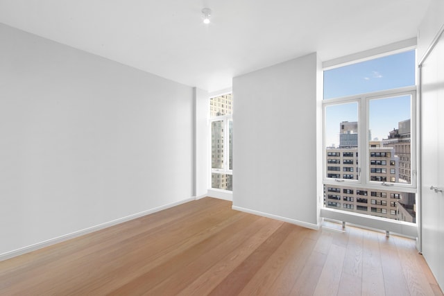 5 Beekman St Unit 22C, New York City, NY 10038 - empty room with light wood-style floors, baseboards, and a city view