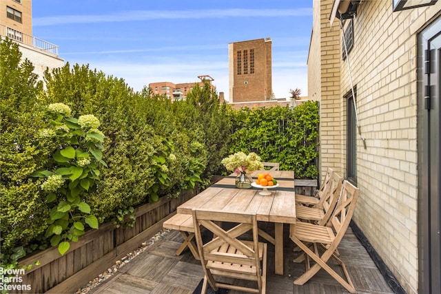 view of wooden balcony featuring a wooden deck and outdoor dining area