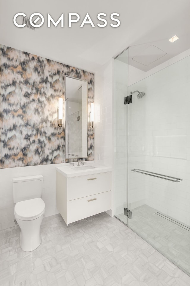 200 E 83rd St Unit 24C, New York City, NY 10028 - bathroom featuring a shower stall, toilet, vanity, tile patterned floors, and wallpapered walls
