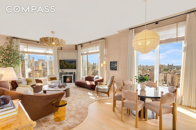 200 E 83rd St Unit 24C, New York City, NY 10028 - living area with a chandelier, wood finished floors, healthy amount of natural light, and a fireplace
