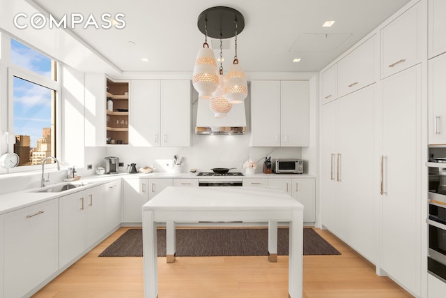 200 E 83rd St Unit 24C, New York City, NY 10028 - kitchen featuring a sink, white cabinets, light wood-type flooring, light countertops, and recessed lighting