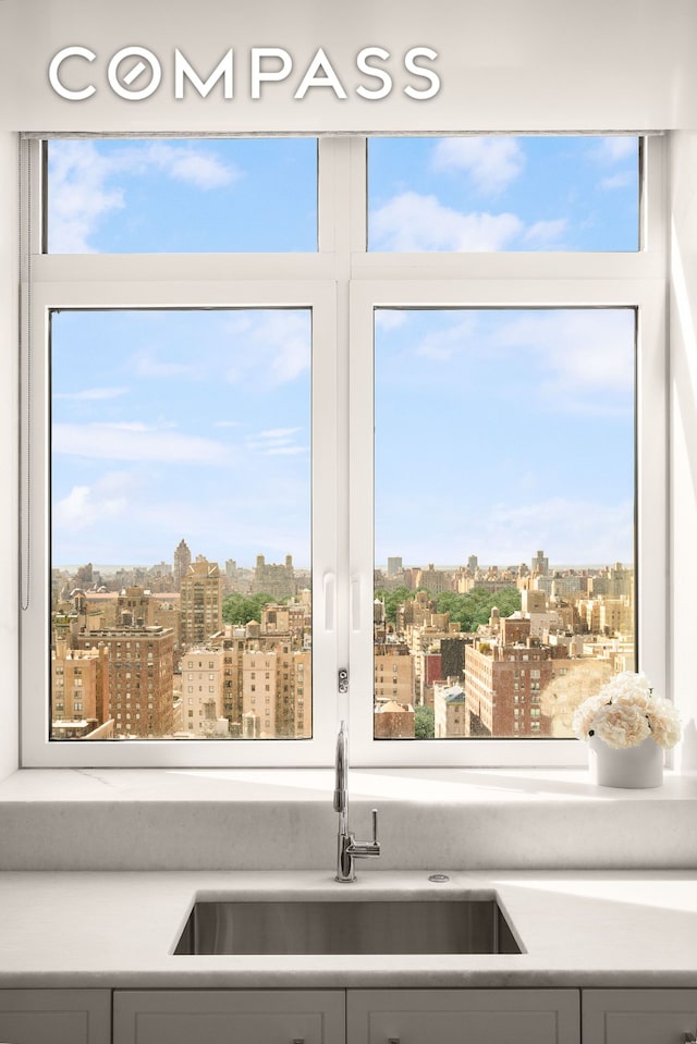 200 E 83rd St Unit 24C, New York City, NY 10028 - kitchen view of a sink, a city view, and gray cabinetry