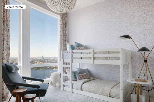 bedroom featuring a water view, wallpapered walls, and carpet floors