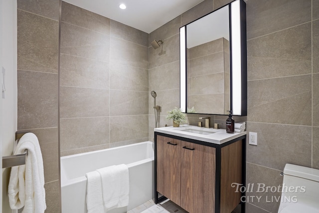 bathroom with shower / washtub combination, vanity, recessed lighting, toilet, and tile walls