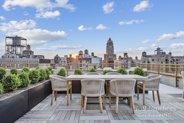 wooden terrace featuring outdoor dining space and a view of city