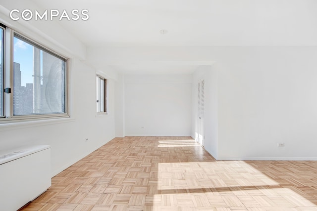 spare room with plenty of natural light and baseboards