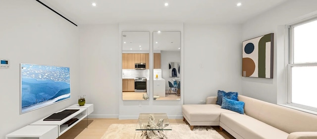 living area featuring light wood-type flooring and recessed lighting