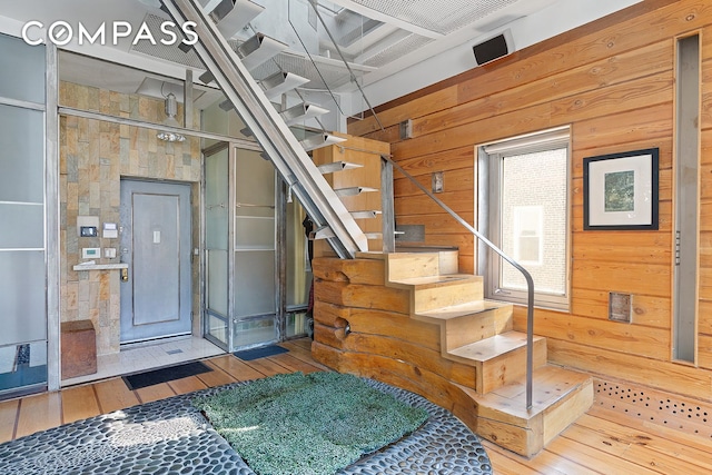 staircase featuring wood walls and hardwood / wood-style floors