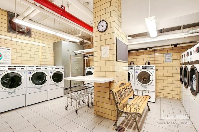 community laundry room with tile walls, light tile patterned floors, and separate washer and dryer