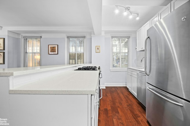 155 E 49th St Unit 1A, New York City, NY 10017 - kitchen featuring stainless steel appliances, white cabinets, dark wood-style flooring, and light stone countertops