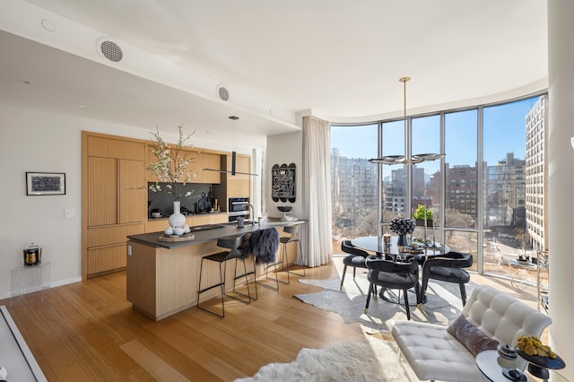 office with light wood-type flooring, expansive windows, a view of city, and baseboards