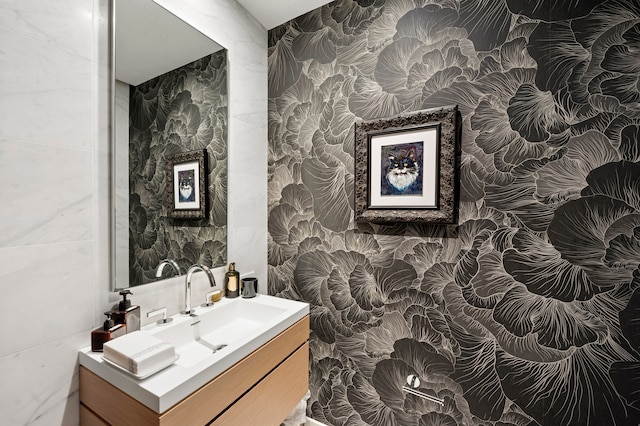 bathroom featuring wallpapered walls, tile walls, and vanity