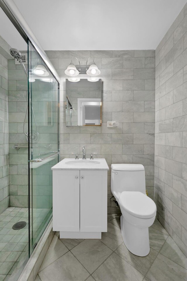 415 E 52nd St Unit 3Aa, New York City, NY 10022 - full bathroom featuring tile walls, vanity, a stall shower, toilet, and tile patterned flooring