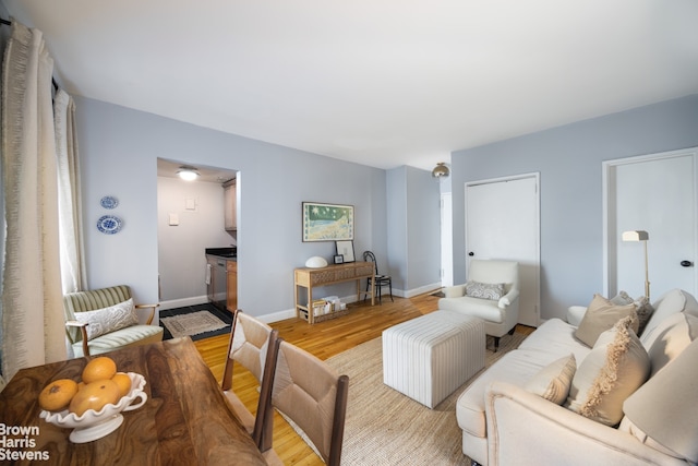living area featuring light wood-style flooring and baseboards